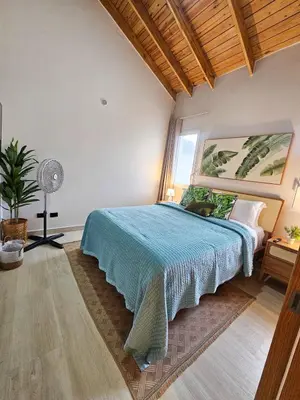 a bedroom with a bed with a blue bedspread at Garden Breeze Penthouse & Pool View l Ghibli 401 in La Laguna