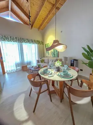 a living room with a table and chairs at Garden Breeze Penthouse & Pool View l Ghibli 401 in La Laguna