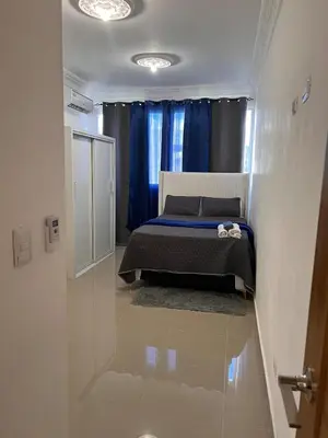 a bedroom with a bed and a blue curtain at Luxury Royalty-1 in Santa Cruz de Barahona