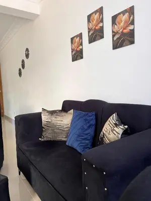 a black couch in a living room with pictures on the wall at Luxury Royalty-1 in Santa Cruz de Barahona
