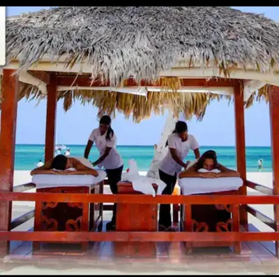 a group of people making beds on the beach at Cocotal Beach Pool and Golf course Punta Cana RD in Colorado
