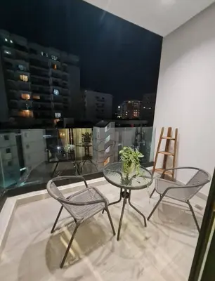 a table and chairs on a balcony with a view of a city at Exclusivo Apartamento de un Dormitorio in Santo Domingo