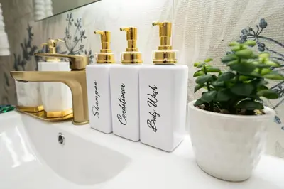 a bathroom counter with three perfume bottles and a potted plant at Santiago s top Residence, Experience it & Believe it in Santiago de los Caballeros