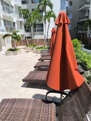 two chairs with umbrellas sitting next to a building at RIKI R Boca del Mar III Apartment 406 in Boca Chica