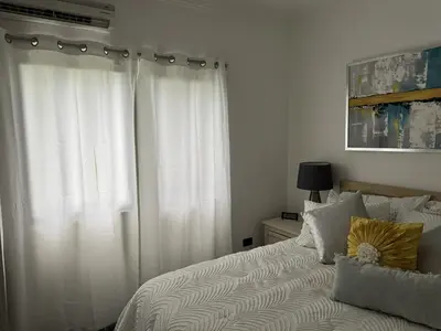 a bedroom with a bed with white curtains at Costa Lunga-Tropicasa in Boca Chica