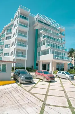three cars parked in a parking lot in front of a building at Vista Marina Residence in Boca Chica