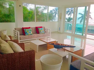 a living room with couches and tables and windows at Vista Marina Residence in Boca Chica