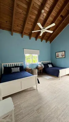 a bedroom with two beds and a ceiling fan at Portillo Beach Family House in El Limón