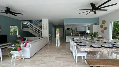 a dining room and living room with a table and chairs at Portillo Beach Family House in El Limón