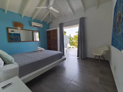 a bedroom with a bed and a sliding glass door at Villas Riviera in Las Terrenas