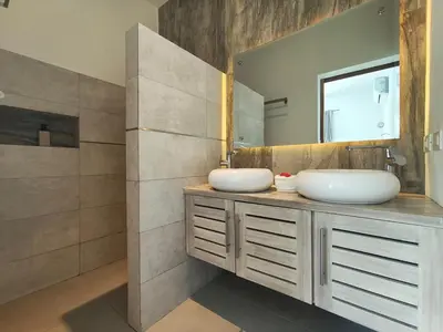 a bathroom with two sinks and a mirror at Villas Riviera in Las Terrenas