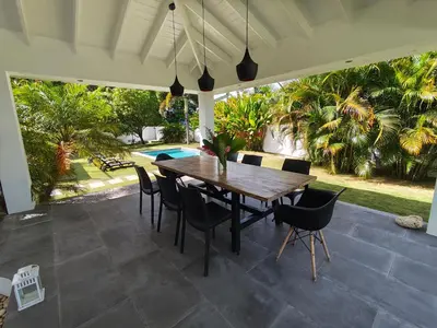 a patio with a wooden table and chairs at Villas Riviera in Las Terrenas