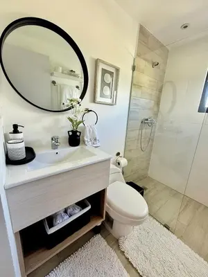 a bathroom with a sink and a toilet and a mirror at Apartment Punta Cana Oasis ONA Residences in Punta Cana