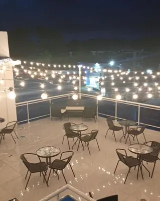 a group of tables and chairs on a deck with lights at El Legendario in Sosúa