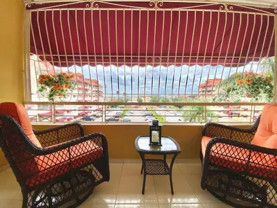 two chairs and a table in front of a large window at Stylish 3BR Condo, Full AC, Wi-Fi in Santo Domingo
