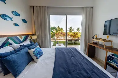 a bedroom with a large bed and a television at Vista Family Garden Suite Pool front 2 Bdrms in Punta Cana