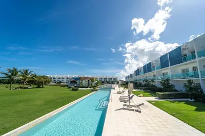 a swimming pool in front of a building at Vista Family Garden Suite Pool front 2 Bdrms in Punta Cana