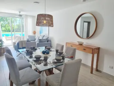a dining room with a table and chairs and a mirror at Aqua Pearl ! Pool Access 2 BRM J 102 in Punta Cana