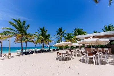 a beach with chairs and umbrellas on the beach at Aqua Pearl ! Pool Access 2 BRM J 102 in Punta Cana