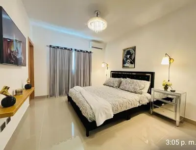 a bedroom with a large bed and a television at Tranquilo y acogedor in Santiago de los Caballeros