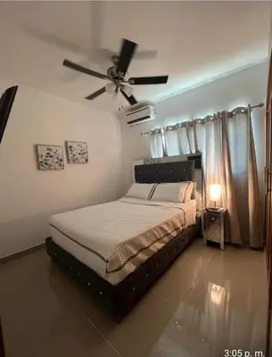 a bedroom with a bed and a ceiling fan at Tranquilo y acogedor in Santiago de los Caballeros