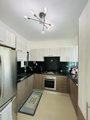 a kitchen with wooden cabinets and a stainless steel refrigerator at Tranquilo y acogedor in Santiago de los Caballeros