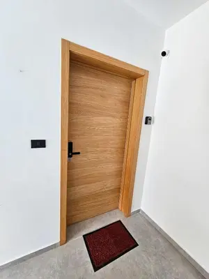 a wooden door in a white room with a red rug at Estrella Garden Condos Dominicus l Meridiana 204 in La Laguna