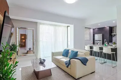a living room with a couch and a kitchen at Upscale City Center Condo Pool in Santo Domingo