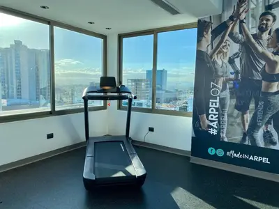 a gym with a treadmill in a room with windows at Upscale City Center Condo Pool in Santo Domingo
