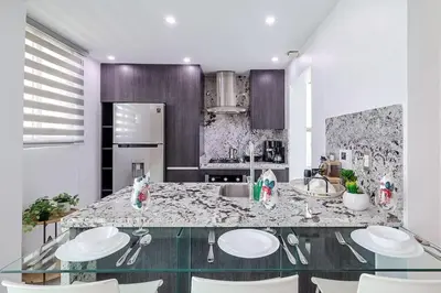 a kitchen with a glass table with white plates on it at Upscale City Center Condo Pool in Santo Domingo