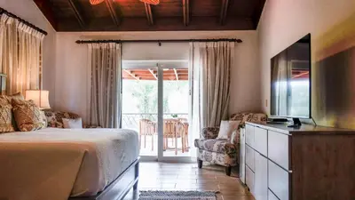 a bedroom with a bed and a tv and a balcony at Villa Polo Luxury Villa in Casa de Campo, La Romana in La Romana