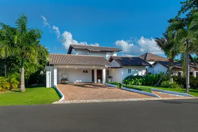 a white house with a driveway and palm trees at Villa Polo Luxury Villa in Casa de Campo, La Romana in La Romana