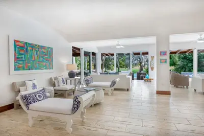 a living room with white furniture and windows at Villa Polo Luxury Villa in Casa de Campo, La Romana in La Romana