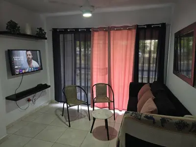 a living room with a couch and chairs and a tv at Apartamento palmera del este 3 in La Javilla