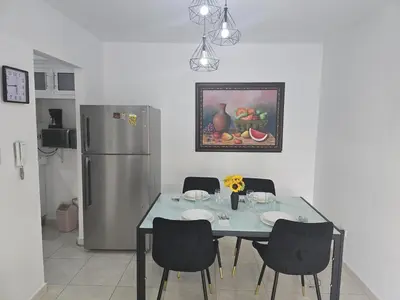 a kitchen with a table with chairs and a refrigerator at Apartamento palmera del este 3 in La Javilla