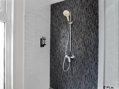 a shower with a shower head in a bathroom at Stay at Ultravioleta Cabarete Beachfront Apartments by EvoKey in Cabarete