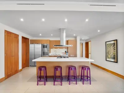 a kitchen with purple stools around a kitchen island at Stay at Ultravioleta Cabarete Beachfront Apartments by EvoKey in Cabarete