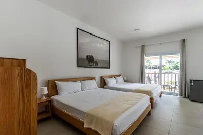 a hotel room with two beds and a balcony at Laguna Park Apartments in Sosúa