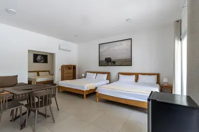a hotel room with two beds and a tv at Laguna Park Apartments in Sosúa