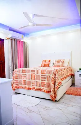 a bedroom with a bed with orange and white comforter at Apartamento en el malecón cerca de la playa in San Felipe de Puerto Plata