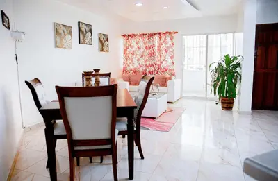 a dining room and living room with a table and chairs at Apartamento en el malecón cerca de la playa in San Felipe de Puerto Plata