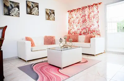 a living room with two white couches and a rug at Apartamento en el malecón cerca de la playa in San Felipe de Puerto Plata