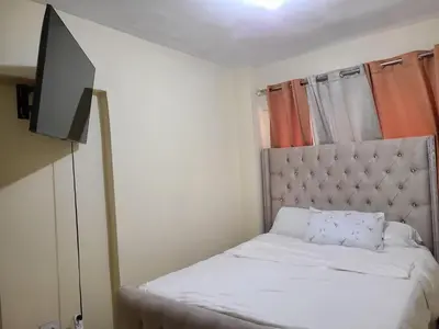 a small bedroom with a bed and a flat screen tv at Apartment5Start in Santo Domingo