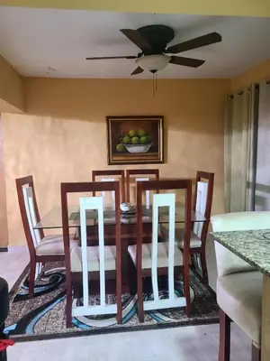 a dining room table with chairs and a ceiling fan at Apartment5Start in Santo Domingo