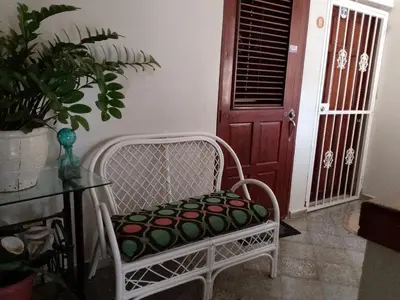 a white chair with a pillow on a table and a door at Apartaestudio en el malecón y cerca de playas in San Felipe de Puerto Plata