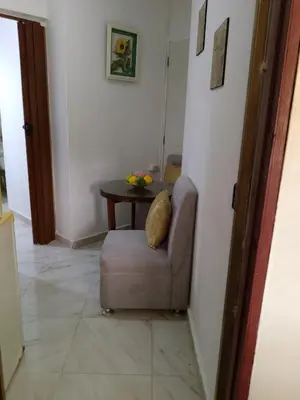 a living room with a chair and a table at Apartaestudio en el malecón y cerca de playas in San Felipe de Puerto Plata