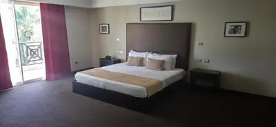 a hotel room with a bed and a large window at LTH Las Terrenas Hotel in Las Terrenas