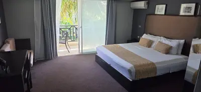 a hotel room with a bed and a balcony at LTH Las Terrenas Hotel in Las Terrenas