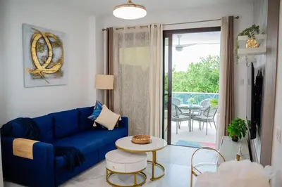 a living room with a blue couch and a table at Ocean Blue at Cana Rock Star in Punta Cana
