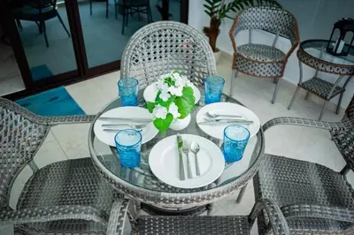 a glass table with plates and flowers on it at Ocean Blue at Cana Rock Star in Punta Cana